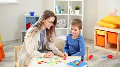Image showing a child participating in speech therapy, with a therapist providing guidance and support. The therapy is tailored to the child's needs, helping them improve communication skills and speech development. The setting highlights the personalized approach of speech therapy for children.